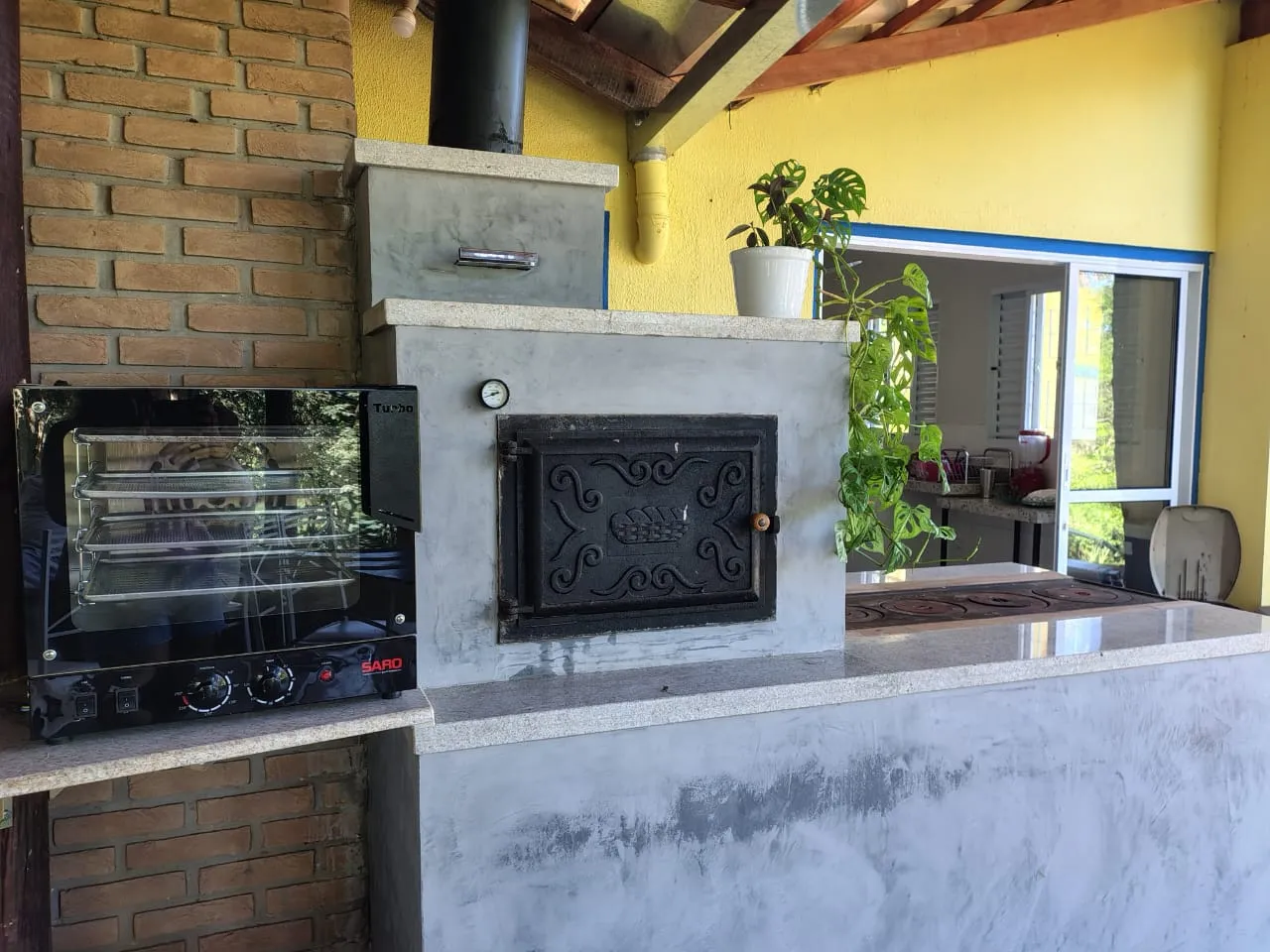 Quiosque com churrasqueira e forno de pizza